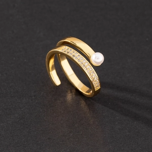 Macro view of gold adjustable spiral ring with white pearl and pave zirconia detail