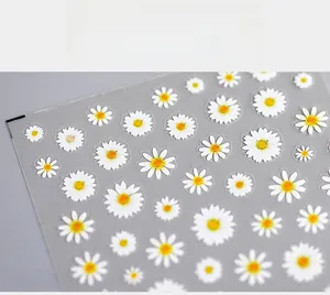 Detailed macro view of white daisy 5D nail art stickers with yellow centers on transparent film