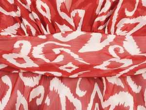 Détail de l'imprimé ikat rouge géométrique et de la taille en mousseline du vêtement