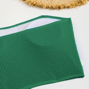 Detail of green wavy textured bikini top with removable pads and straw hat accent
