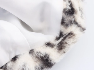 Detailed close-up of leopard faux fur trim and smooth white satin inner lining texture