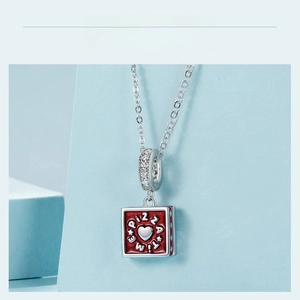 Macro shot of silver pizza pendant with red enamel heart detail and PIZZA TIME text