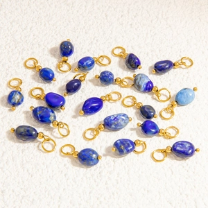 Detailed view of lapis blue natural stone pendants with gold circular jump rings