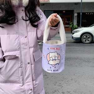 Dettaglio della borsa a secchiello in tela viola chiaro con manico morbido e orsetto cute