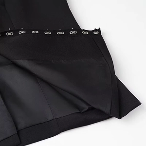 Macro shot of elegant hook-and-eye metal closures on black tailored trouser waistband