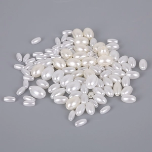 Detailed close-up of oval ABS imitation pearl beads with lustrous cream white finish