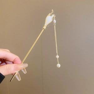 Détail d'une épingle à cheveux chinoise dorée avec bouton de fleur et pompon perlé