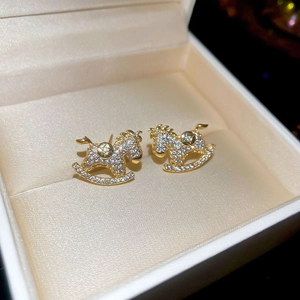 Macro detail of 18k gold plated rocking horse stud earrings with sparkling pavé crystals