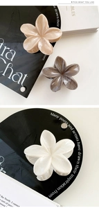 Close-up of flower hair claws in cream, grey, and white with elegant marble texture