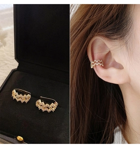 Macro detail of wave-shaped gold ear cuff with sparkling zircons and a model wearing view