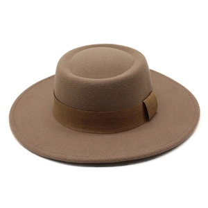 Detail showing the flat crown and wide brim of the camel wool felt hat with brown ribbon