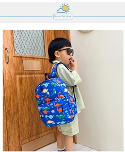 Blue toddler backpack with colorful dinosaur prints worn by child in a cozy home setting