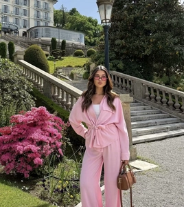 Outdoor shot of a pink casual two-piece set with a belted shirt and flowing pants