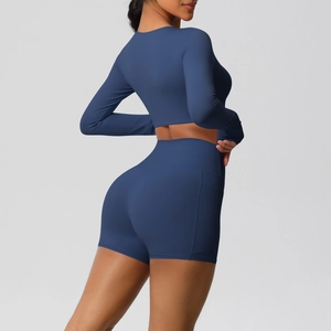 Detailweergave van de marineblauwe yogaset met zijzak op de korte broek en top met lange mouwen