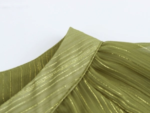 Detailed close-up of the round neckline and gold vertical stripes on olive chiffon fabric