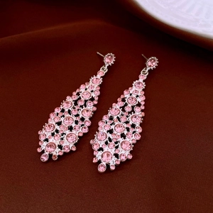 Detail of pink crystal teardrop earrings with silver metal tassel and rhinestone inlay