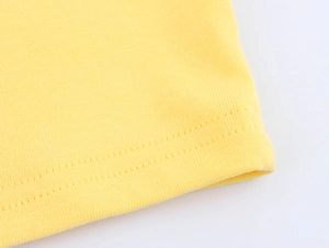 Close-up of bright yellow cotton t-shirt fabric showing durable double-needle stitching