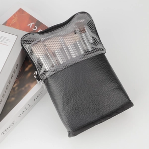Close-up of black leather and grey mesh makeup brush bag with dual zippers in vertical style
