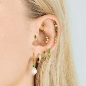 Detail view of S925 silver gold earrings with green emerald zircon and a white pearl charm