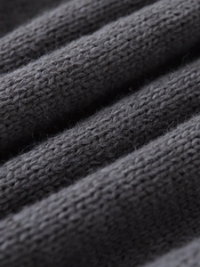 Vista macro dettagliata della trama in maglia a coste grigio scuro con finitura morbida