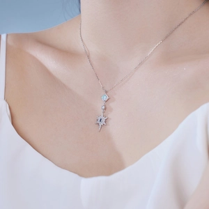 Close-up of S925 silver necklace with opal and zircon pendant on female model