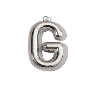Macro view of mirror-polished silver letter G balloon pendant with metal ring