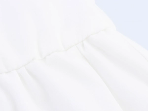 Detail of white beach dress fabric showing high-quality stitching and pleated texture