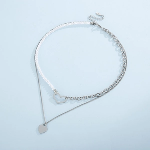 Double-layered stainless steel necklace with pearls and heart pendants on blue background