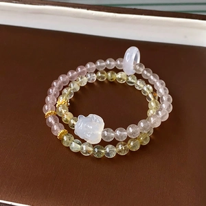 Detail of beaded bracelets with pink quartz and green agate featuring a small jade rabbit charm
