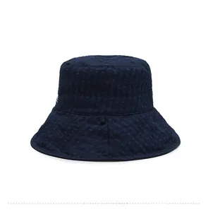 Détail de la texture seersucker bleu marine et des coutures sur le chapeau de soleil