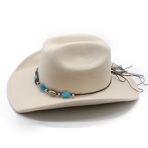 Close-up of felt cowboy hat featuring turquoise stones and vintage metal medallion