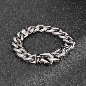Detailed view of silver stainless steel curb chain bracelet with ornate engraved clasp