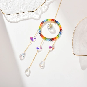 Detail of golden sun catcher featuring rainbow beads and multifaceted crystal sphere