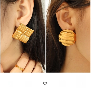 Close-up of exaggerated 18K gold plated geometric earrings and matching ring set