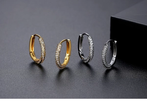 Detail of gold and silver oval hoop earrings featuring micro-pave crystal rhinestones