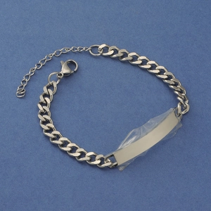 Macro shot of silver stainless steel Cuban link ID bracelet with blank engraving plate