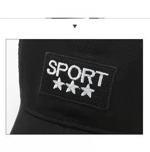 Dettaglio del ricamo SPORT e delle toppe a stella su un berretto nero da baseball