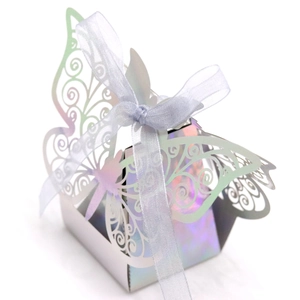 Detail of laser-cut butterfly candy box with iridescent mirror finish and white ribbon