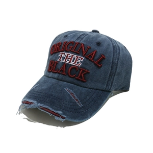 Detailed close-up of vintage washed denim baseball cap with 3D embroidery and distressed brim