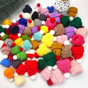 Nahaufnahme von bunten Mini-Strickmützen mit Bommeln für DIY-Puppendekorationen