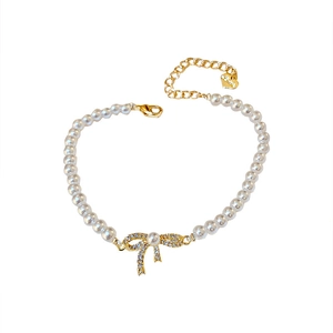 Elegant gold plated baroque bow pearl bracelet with shimmering rhinestone heart charm