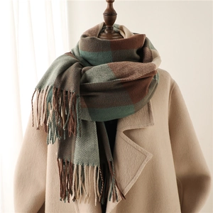 Plaid tassel scarf in brown and green check pattern on mannequin with beige coat