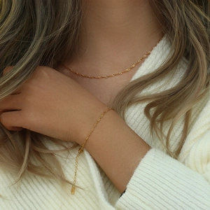 Dettaglio della collana e bracciale a catena a onde d'acqua placcati oro 18K su modella