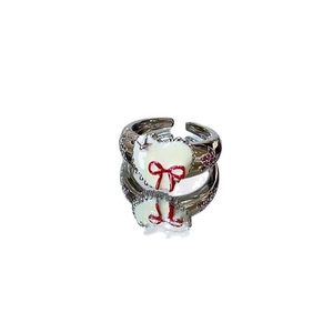 Elegant silver alloy ring with white enamel, red bow and heart design on white background