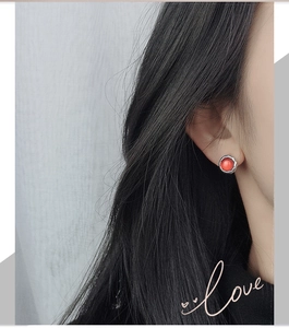 Detailed shot of vintage silver button earrings with red stone and textured edge