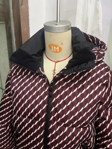 Detail view of winter hooded jacket with burgundy geometric patterns and fleece collar