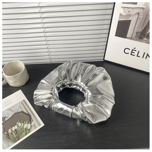 Nahaufnahme der metallisch silbernen Plissee-Handtasche mit einzigartigem Ringdesign