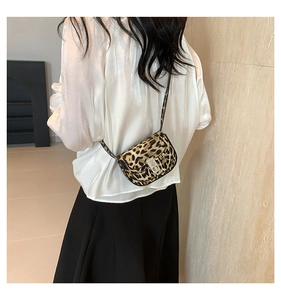 Detailed view of leopard print crossbody bag with silver engraved metal turn-lock