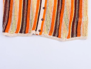 Vue détaillée de la texture en maille à rayures colorées et boutons marron sur l'ourlet