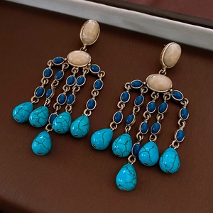 Macro view of vintage turquoise bead tassel earrings with retro gold metal base